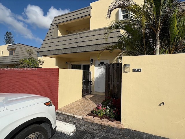 8317 SW 137th Ave Unit 8317, Miami, FL 33183 - view of side of property with a gate, stucco siding, and a fenced front yard