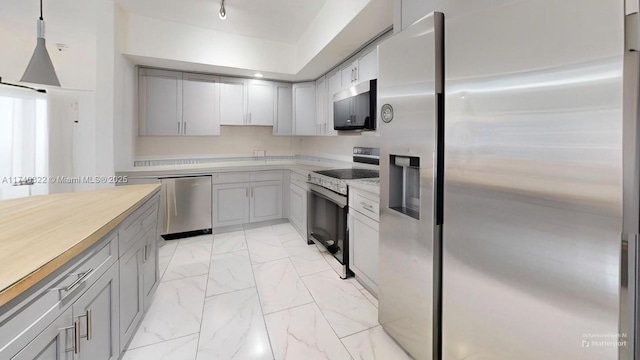 kitchen featuring gray cabinets, appliances with stainless steel finishes, and pendant lighting