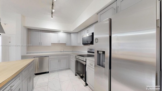 kitchen featuring stainless steel appliances, gray cabinets, and track lighting