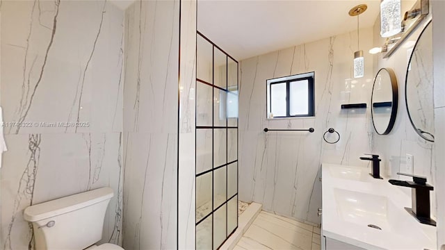 bathroom featuring vanity, tiled shower, tile walls, and toilet