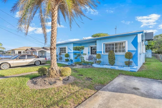 ranch-style home with a front yard, central AC unit, and covered porch