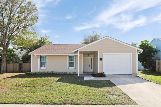 single story home featuring a garage and a front lawn