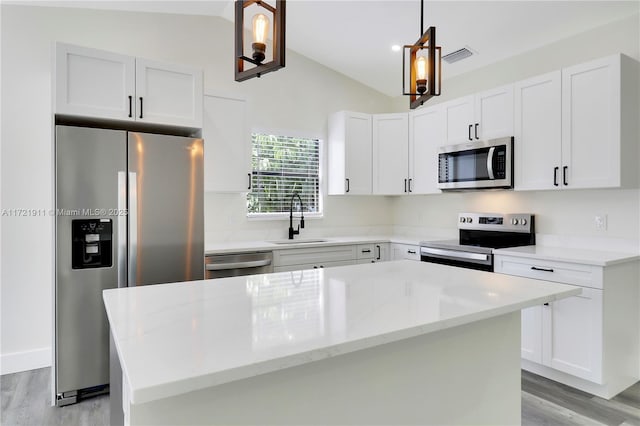 kitchen featuring stainless steel appliances, a kitchen island, sink, white cabinets, and pendant lighting