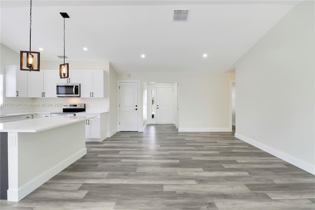 kitchen featuring a center island, pendant lighting, light hardwood / wood-style floors, stainless steel appliances, and white cabinets