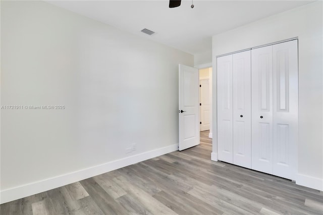 unfurnished bedroom with a closet, ceiling fan, and light wood-type flooring