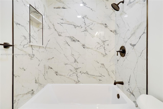 bathroom featuring toilet and tiled shower / bath