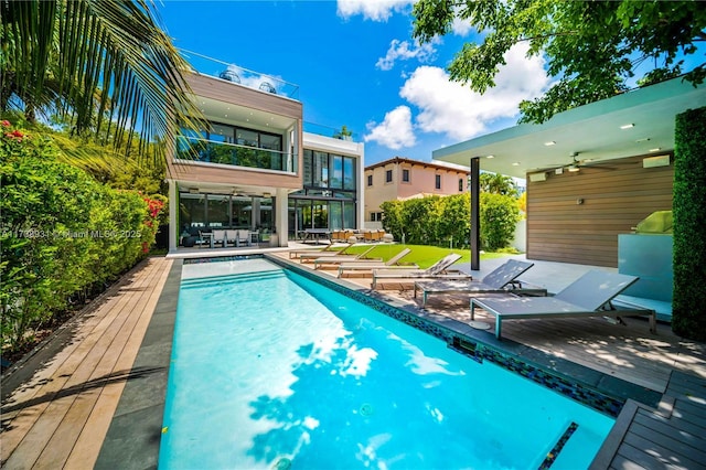 view of swimming pool featuring ceiling fan and a patio