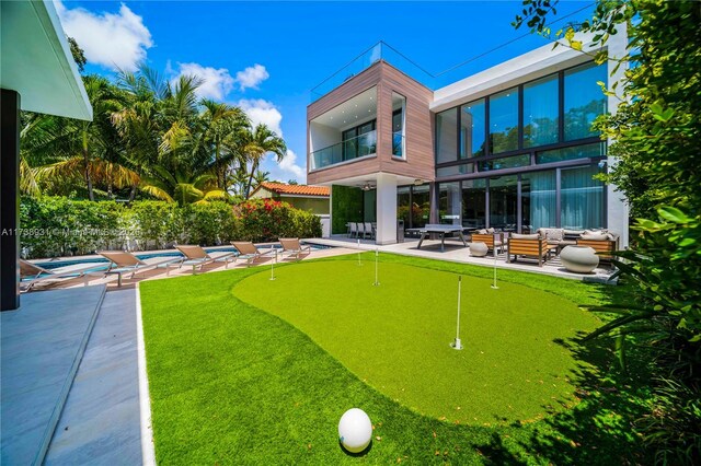 rear view of house featuring a pool, a patio area, outdoor lounge area, and a balcony