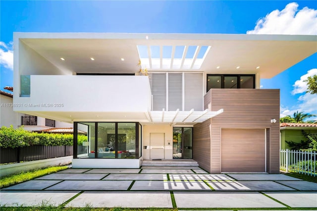 back of property with an attached garage, stucco siding, fence, and a pergola