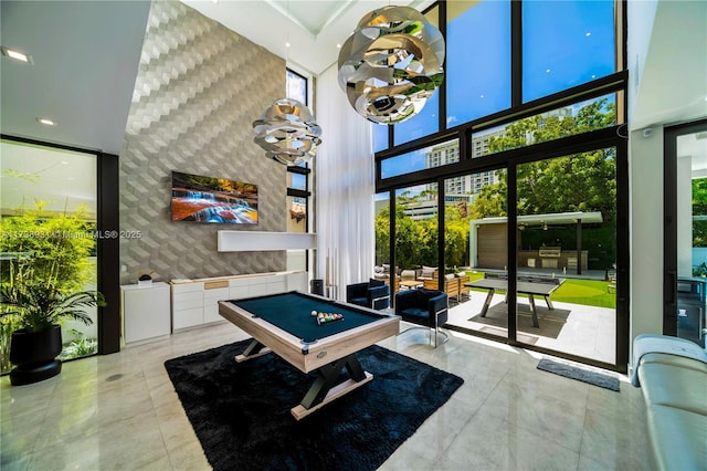 recreation room featuring expansive windows, a high ceiling, and pool table