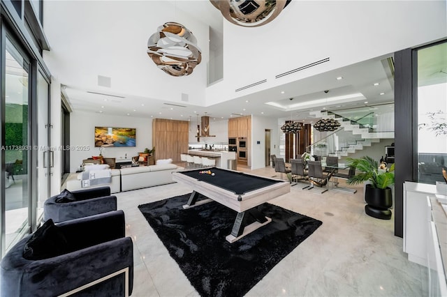 game room with a towering ceiling, visible vents, and recessed lighting