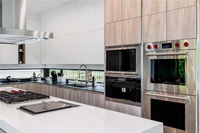 kitchen featuring light brown cabinetry, sink, stainless steel appliances, and island exhaust hood