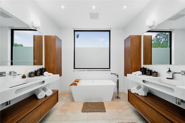 bathroom featuring tile patterned flooring, vanity, and a tub