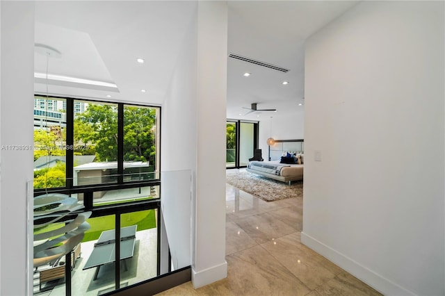 interior space with expansive windows, baseboards, a wealth of natural light, and recessed lighting