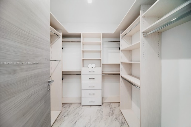 walk in closet with marble finish floor