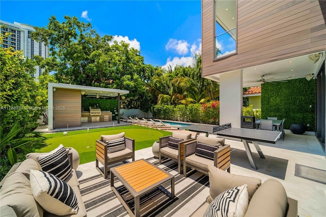 view of patio / terrace featuring exterior kitchen, ceiling fan, an outdoor living space, and a fenced in pool