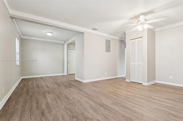 spare room featuring crown molding, ceiling fan, electric panel, and light hardwood / wood-style floors