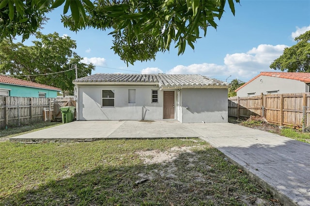 back of house with a yard and a patio area