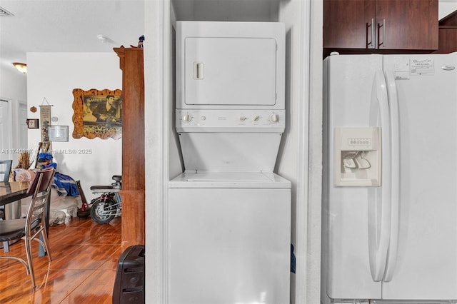 washroom with wood-type flooring and stacked washer and clothes dryer