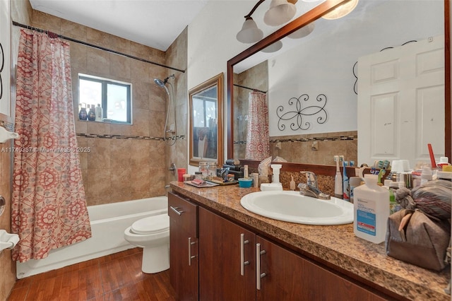 full bathroom featuring vanity, hardwood / wood-style floors, shower / bath combination with curtain, and toilet