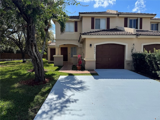 mediterranean / spanish house with a garage and a front yard