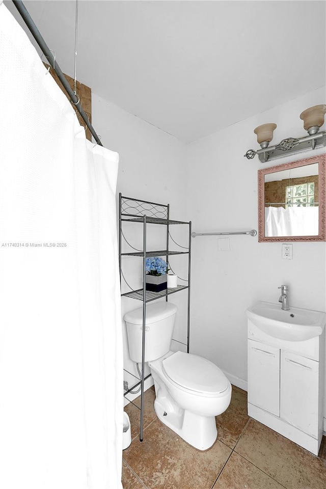 bathroom featuring vanity, toilet, and tile patterned flooring