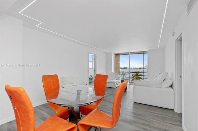 dining area featuring expansive windows and hardwood / wood-style floors