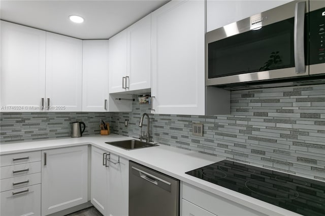 kitchen with appliances with stainless steel finishes, sink, and white cabinets