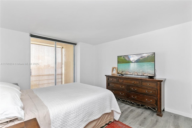 bedroom with access to exterior and light hardwood / wood-style floors