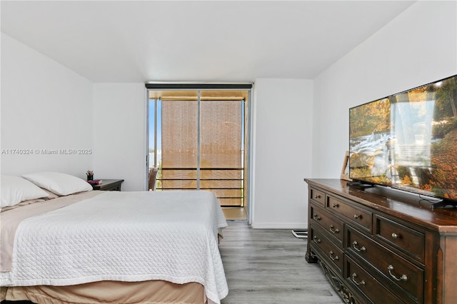 bedroom with light hardwood / wood-style floors and expansive windows