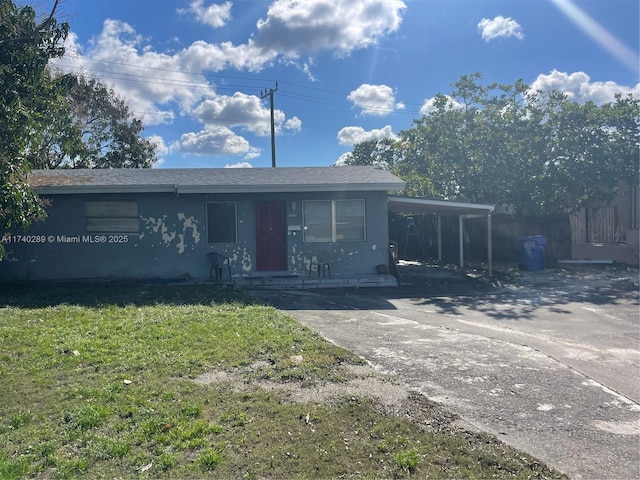 view of front of house featuring a carport and a front yard