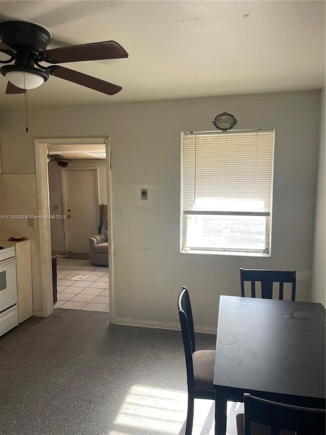 unfurnished dining area with ceiling fan and light tile patterned flooring