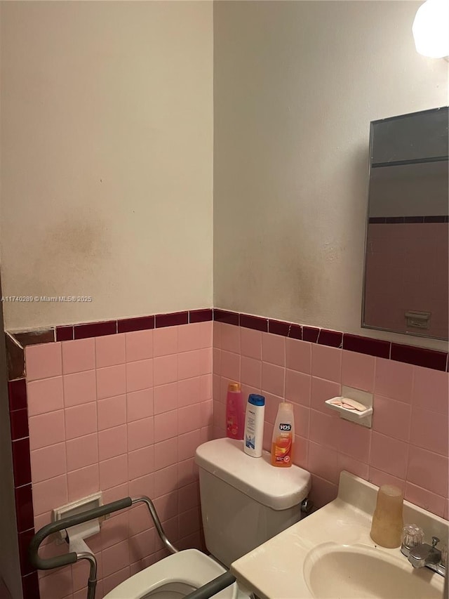 bathroom featuring vanity, toilet, and tile walls