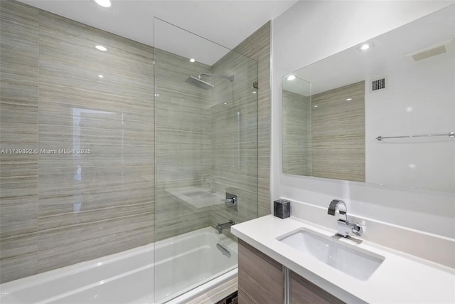 bathroom featuring tiled shower / bath and vanity