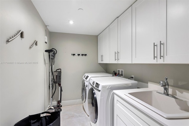 laundry room with cabinets, washer and dryer, sink, and light tile patterned floors