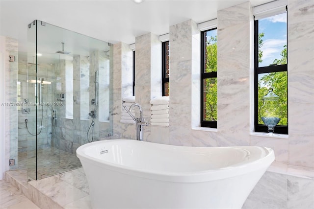 bathroom featuring shower with separate bathtub and tile walls