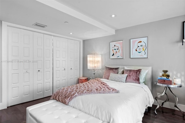 bedroom with dark wood-type flooring and a closet