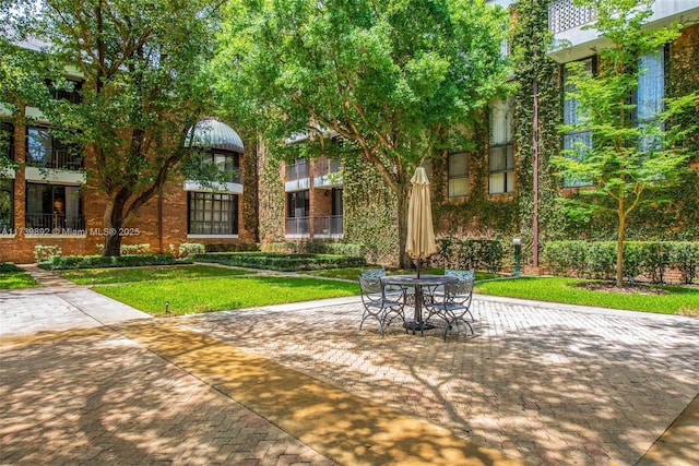 view of home's community featuring a patio and a lawn