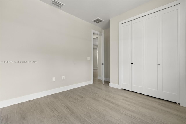 unfurnished bedroom with a closet and light wood-type flooring