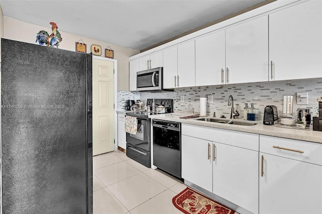 kitchen featuring sink, white cabinetry, black appliances, light tile patterned flooring, and decorative backsplash