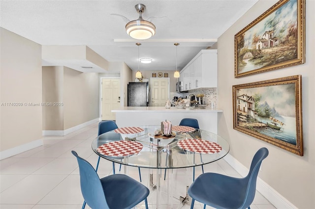 tiled dining room with a textured ceiling