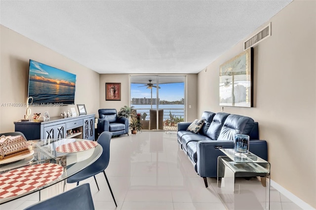 living room with expansive windows, light tile patterned flooring, and a textured ceiling