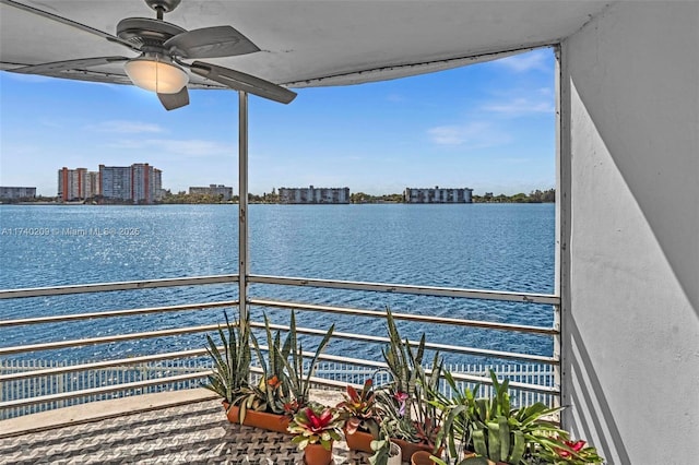 balcony featuring a water view and ceiling fan