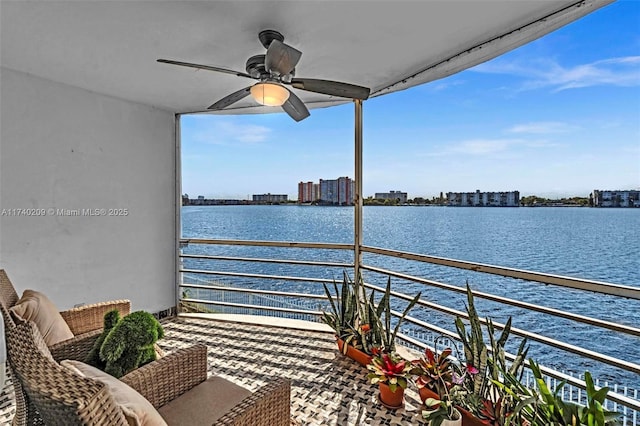 balcony with ceiling fan and a water view