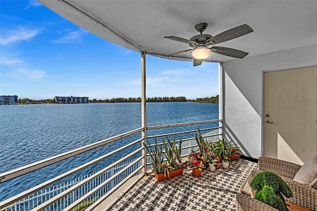 balcony with ceiling fan and a water view