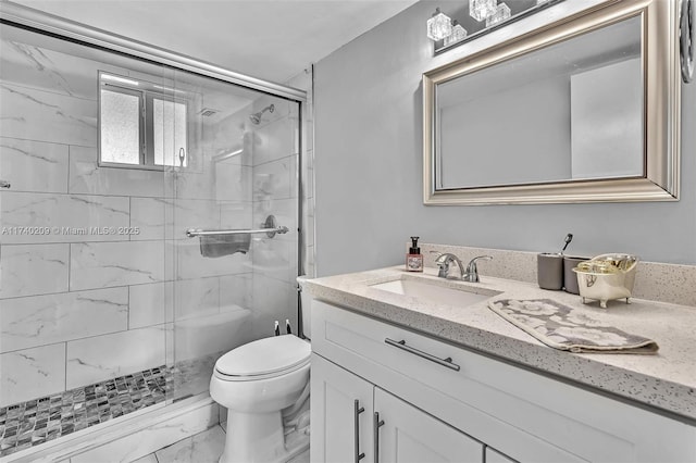 bathroom featuring vanity, toilet, and a shower with shower door