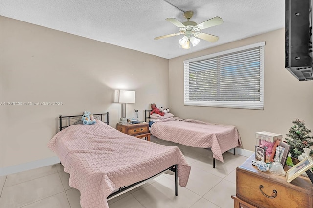 bedroom featuring ceiling fan, a textured ceiling, and light tile patterned flooring