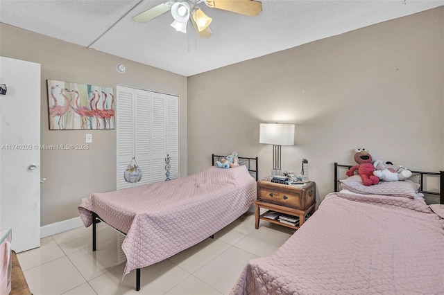 tiled bedroom with ceiling fan and a closet