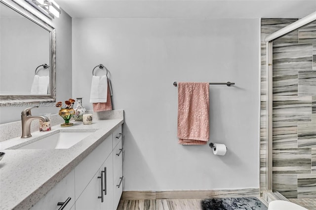 bathroom with vanity, hardwood / wood-style flooring, and a shower with shower door