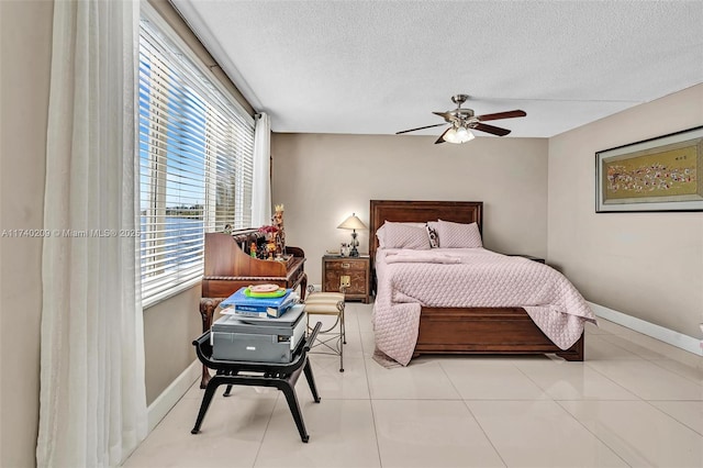 tiled bedroom with ceiling fan and a textured ceiling